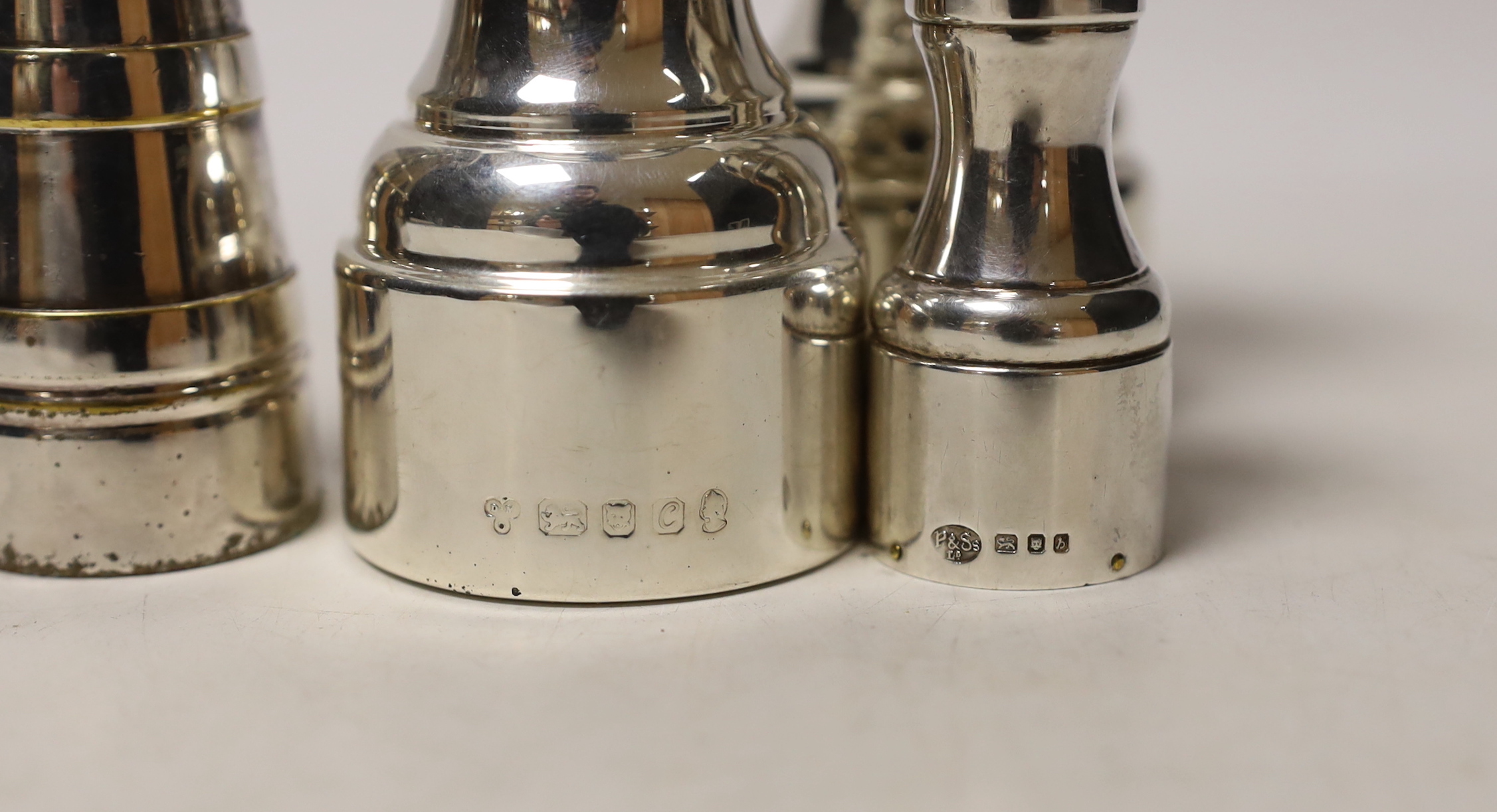 Three assorted modern silver pepper mills, largest 10.5cm and one plated pepper mill.